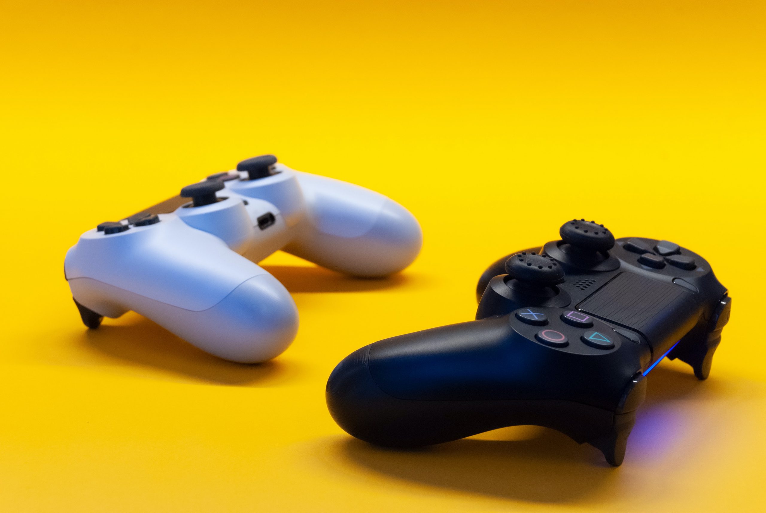 White and Black Play Station Controller on yellow background